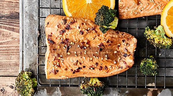 Sheet Pan Asian Salmon and Broccoli. A healthy one pan meal loaded with salmon, broccoli, and an Asian inspired marinade: soy sauce, orange juice, sesame oil, hoisin sauce, garlic powder, ginger, pepper, and crushed red pepper. Only 10 ingredients and 10 minutes of prep! showmetheyummy.com #sheetpan #dinner #healthy #salmon #asian #broccoli