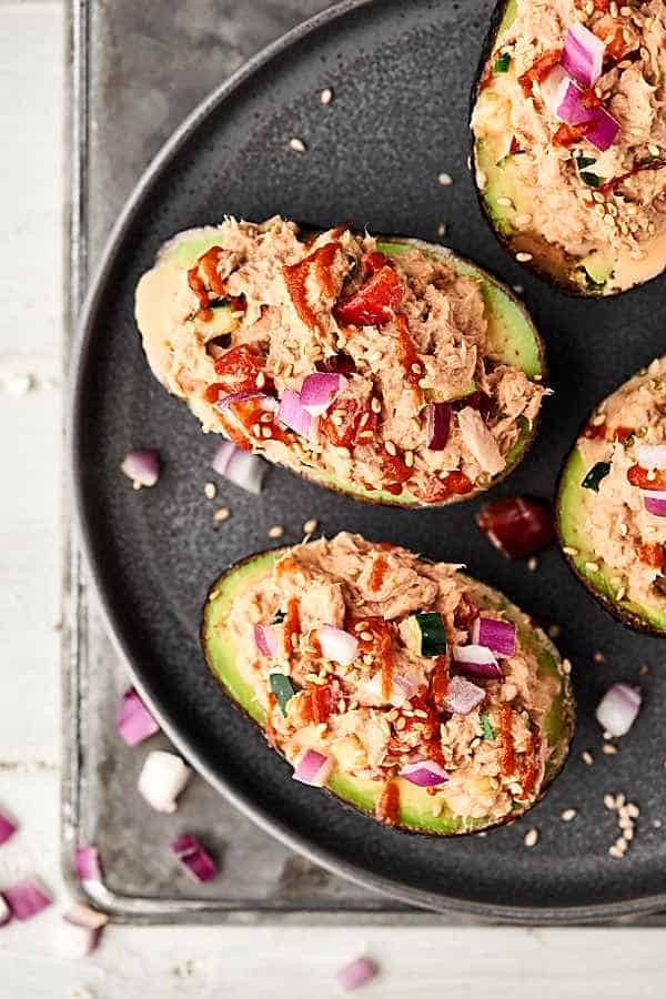 spicy tuna roll stuffed avocados on plate above