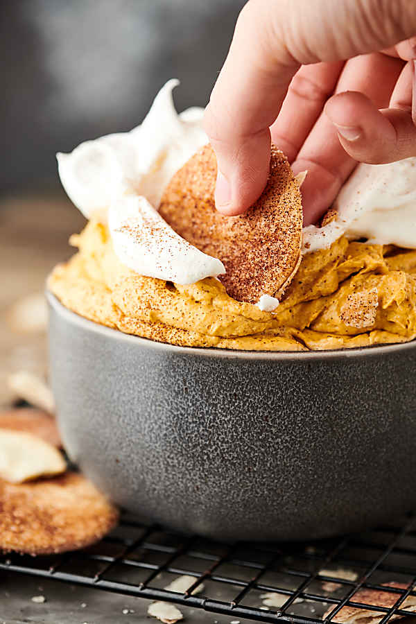 pie crust cookie being dipped into bowl of pumpkin pie dip