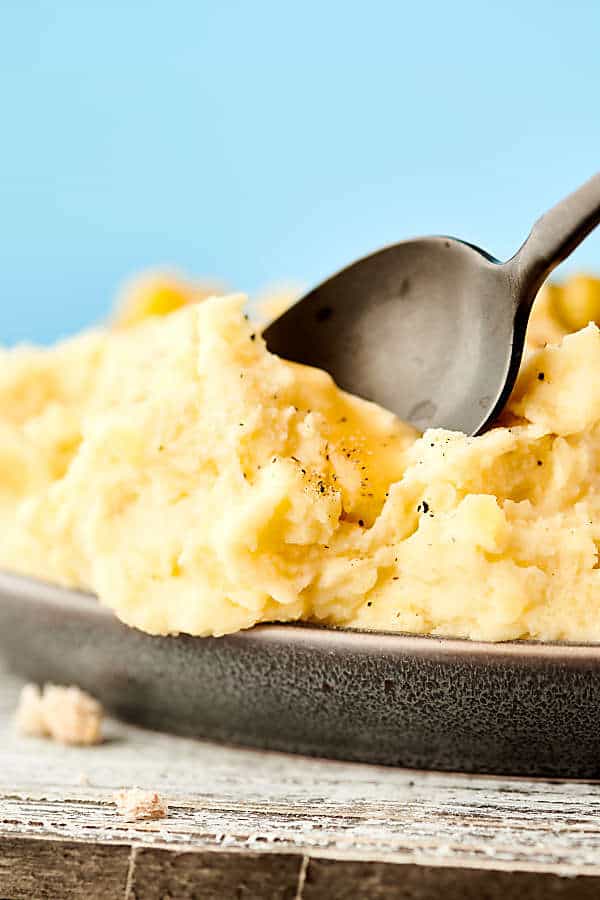 spoon dipped into plate of mashed potatoes