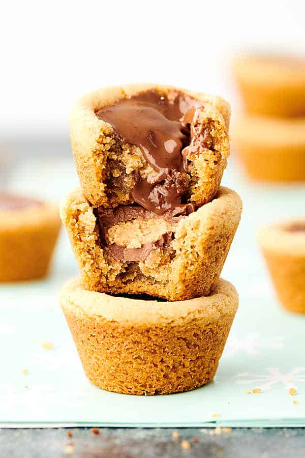 These Easy Peanut Butter Cup Cookies are a holiday classic! Homemade peanut butter cookie dough is baked in a mini muffin tin and stuffed with a Reese's Peanut Butter Cup. YUM. showmetheyummy.com #peanutbuttercupcookie #peanutbuttercup #peanutbutter #cookie #christmascookie