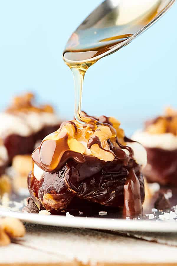 walnut and greek yogurt stuffed date being drizzled with honey