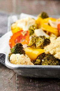 Only 10 ingredients and 30 minutes necessary for this Easy Roasted Vegetables Recipe! Cauliflower, broccoli, onion, peppers, garlic, oil, apple cider vinegar, salt and pepper! Don't like some of those veggies? Just swap them out for your favorites! Only 115 calories. Vegan. Gluten Free. showmetheyummy.com #roastedvegetables #vegan #glutenfree #healthy #recipe