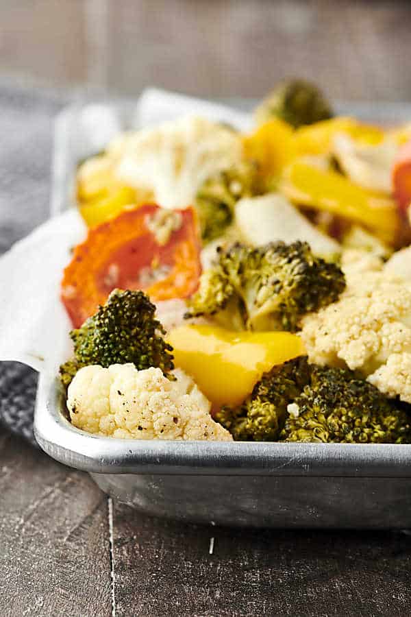 Only 10 ingredients and 30 minutes necessary for this Easy Roasted Vegetables Recipe! Cauliflower, broccoli, onion, peppers, garlic, oil, apple cider vinegar, salt and pepper! Don't like some of those veggies? Just swap them out for your favorites! Only 115 calories. Vegan. Gluten Free. showmetheyummy.com #roastedvegetables #vegan #glutenfree #healthy #recipe