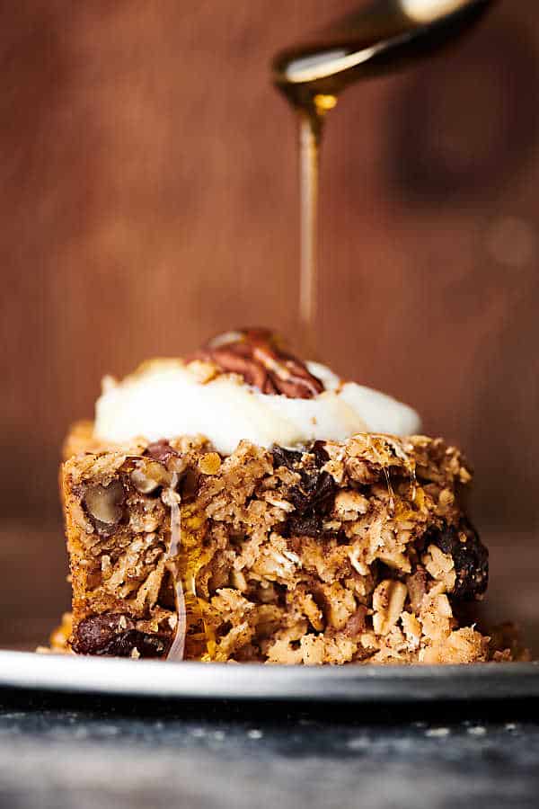 maple syrup being drizzled on slice of baked oatmeal