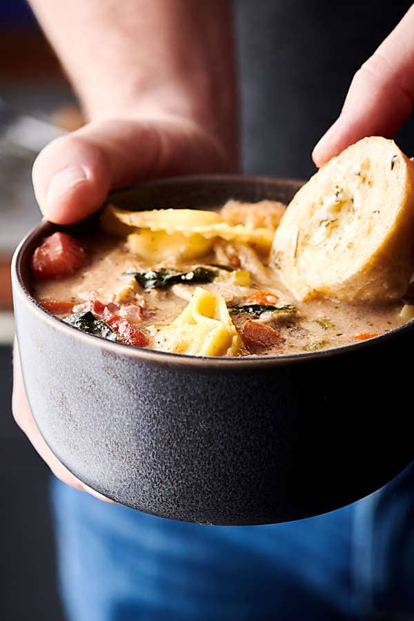 Chicken Tortellini Soup. An easy, cozy soup loaded with onions, carrots, celery, garlic, Italian seasoning, chicken broth, milk, fat free half-and-half (or heavy cream), a touch of white wine, store-bought rotisserie chicken, tomatoes, spinach, cheese tortellini, and parmesan cheese! Only 233 calories per cup! showmetheyummy.com #chicken #tortellini #soup #healthy #spinach