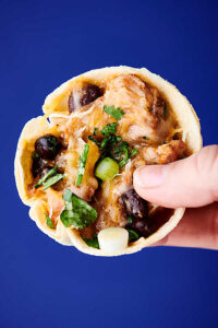 {New!} #ad These Easy Carnitas Enchilada Cups are a fun twist on a classic! Crispy baked tortilla cups are filled with boneless pork shoulder seasoned carnitas, onion, black beans, green chiles, and enchilada sauce. Topped with melty cheese, sour cream, cilantro, and a squeeze of lime! showmetheyummy.com Made in partnership w/ Smithfield #RealFlavorRealFast #pork #carnitas #enchiladas
