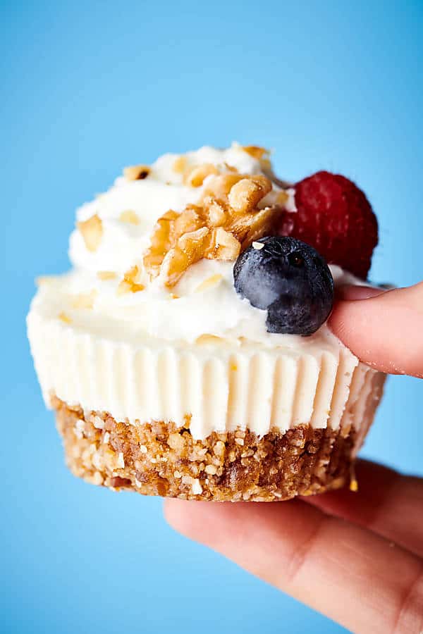 lemon walnut cheesecake held blue background