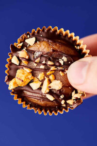 Healthy Date Peanut Butter Cups aka a healthy twist on a classic! These taste like the real deal, but are made with medjool dates, all natural peanut butter, tahini, vanilla, salt, dark chocolate chips, coconut oil, and roasted peanuts for crunch! Vegan. Gluten Free. Quick and easy! showmetheyummy.com #healthy #dates #refinedsugarfree #peanutbutter #naturallysweet #candy #darkchocolate #vegan #homemade #glutenfree #peanutbuttercups