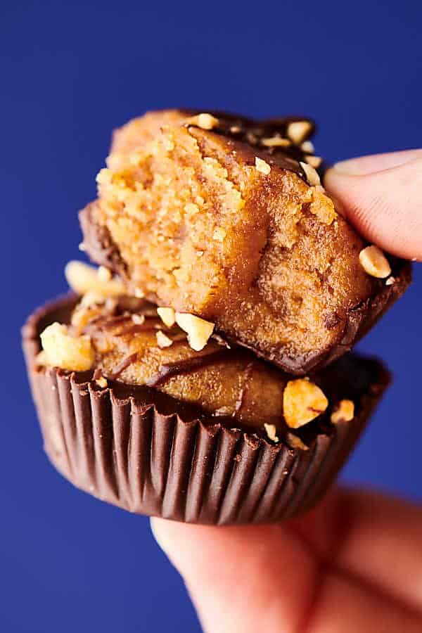 two healthy date peanut butter cups stacked and held