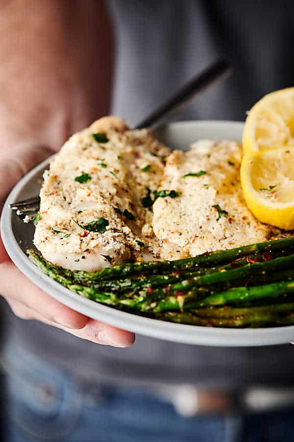 Plate of tilapia and asparagus held
