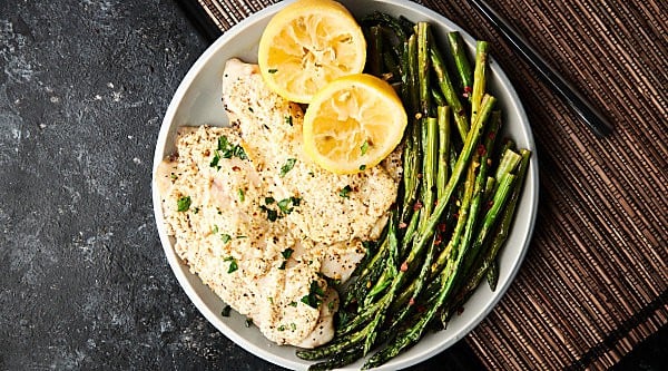 Healthy Greek Yogurt Lemon Parmesan Tilapia Recipe. Baked tilapia covered in greek yogurt, lemon juice, a touch of butter, a dash of parmesan, and spices. Quick, easy, healthy, and gluten free. Less than 200 calories per serving. Perfect for a week night dinner. showmetheyummy.com #healthy #tilapia #glutenfree #dinner #fish #seafood