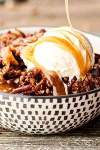 Easy Slow Cooker Carrot Cake Recipe. A layer of instant pudding is topped with pecans, coconut, and carrots, drizzled in caramel sauce, sprinkled with spice cake mix, and then topped with a butter, brown sugar, pecan streusel topping. Quick, easy, and SO decadent. The perfect gooey, fluffy crockpot cake! showmetheyummy.com #slowcooker #crockpot #cake #carrotcake #dessert
