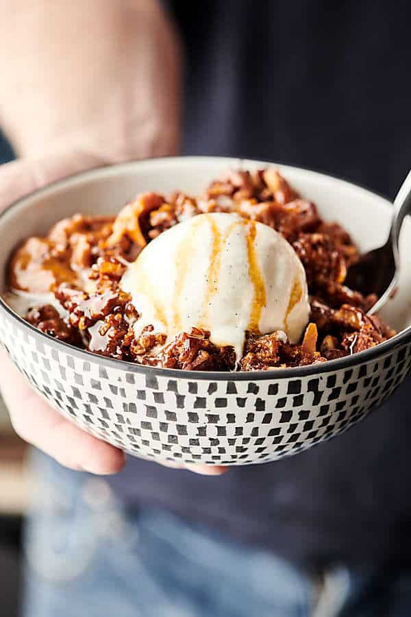 Easy Slow Cooker Carrot Cake Recipe. A layer of instant pudding is topped with pecans, coconut, and carrots, drizzled in caramel sauce, sprinkled with spice cake mix, and then topped with a butter, brown sugar, pecan streusel topping. Quick, easy, and SO decadent. The perfect gooey, fluffy crockpot cake! showmetheyummy.com #slowcooker #crockpot #cake #carrotcake #dessert