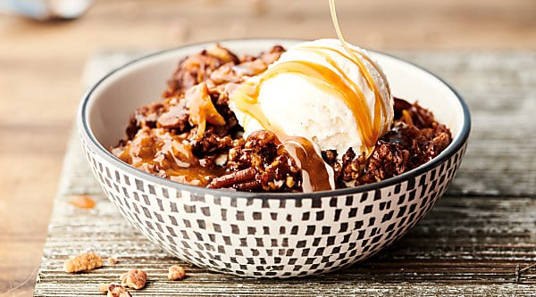Easy Slow Cooker Carrot Cake Recipe. A layer of instant pudding is topped with pecans, coconut, and carrots, drizzled in caramel sauce, sprinkled with spice cake mix, and then topped with a butter, brown sugar, pecan streusel topping. Quick, easy, and SO decadent. The perfect gooey, fluffy crockpot cake! showmetheyummy.com #slowcooker #crockpot #cake #carrotcake #dessert