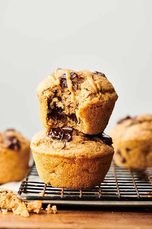 These Healthy Banana Pancake Muffins are loaded with bananas, pure maple syrup, all natural peanut butter, fat free buttermilk, egg, vanilla extract, whole grain protein pancake mix, cinnamon, and dark chocolate chunks! Quick, healthy, and delicious! Freezer friendly. Less than 250 calories per muffin! showmetheyummy.com #healthy #banana #pancake #muffins #chocolate