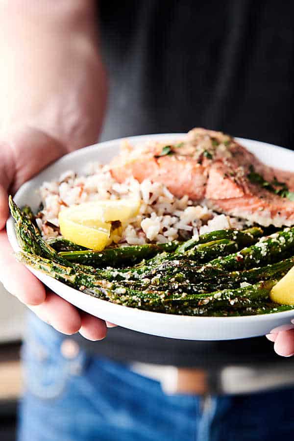 plate of lemon parmesan roasted asparagus held two hands