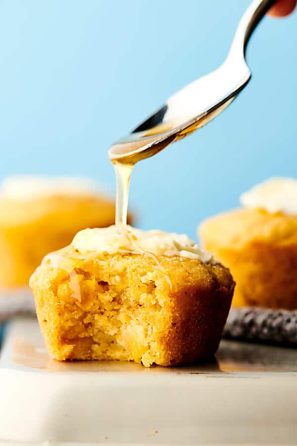 honey being drizzled over cornbread muffin