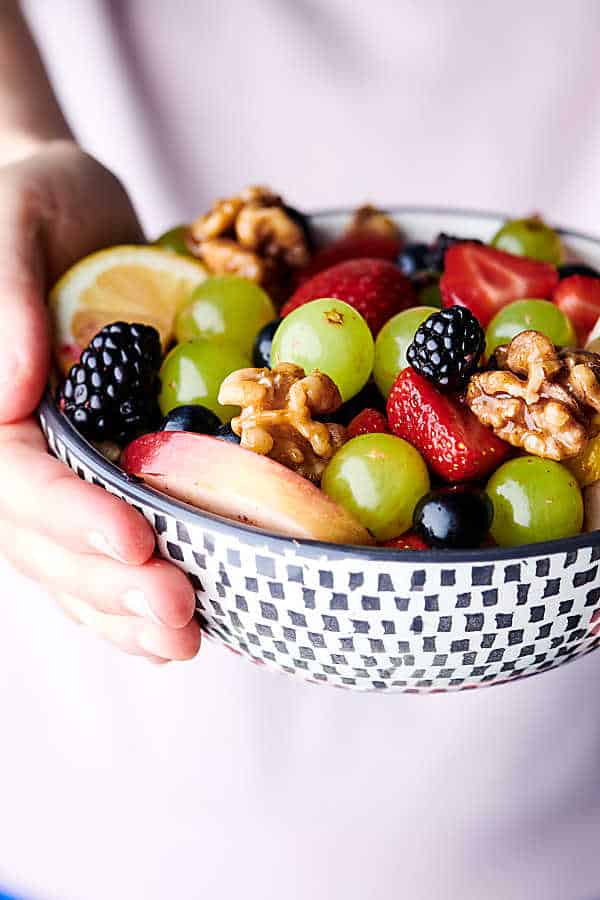 holding fruit salad with honey walnuts