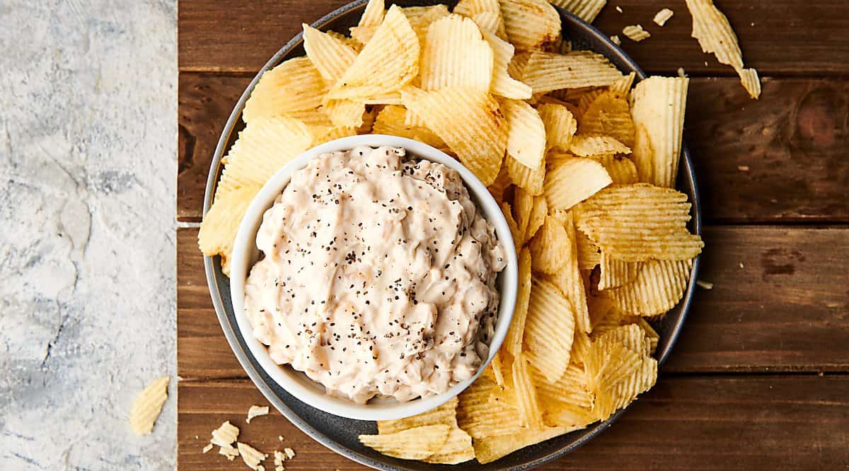 french onion dip on plate with potato chips above