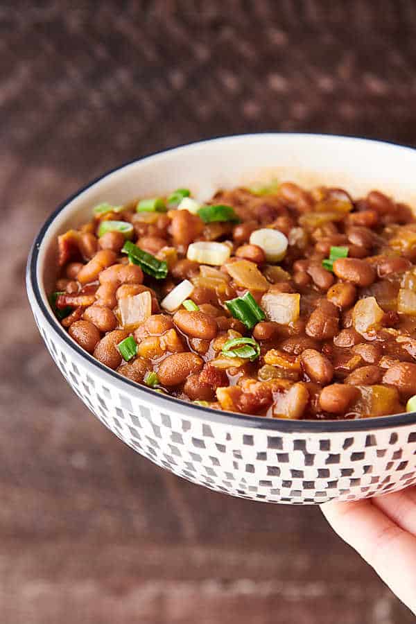 BBQ Baked Beans holding in front of brown background