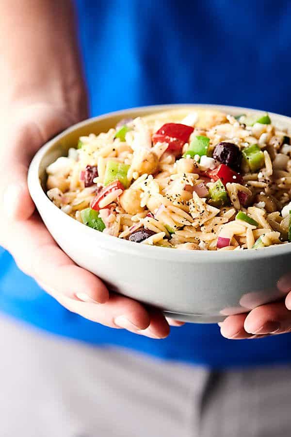 holding Greek orzo salad