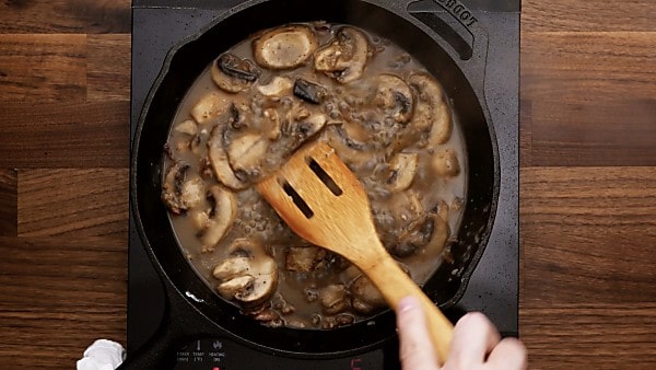 Mushrooms and bacon with broth in skillet