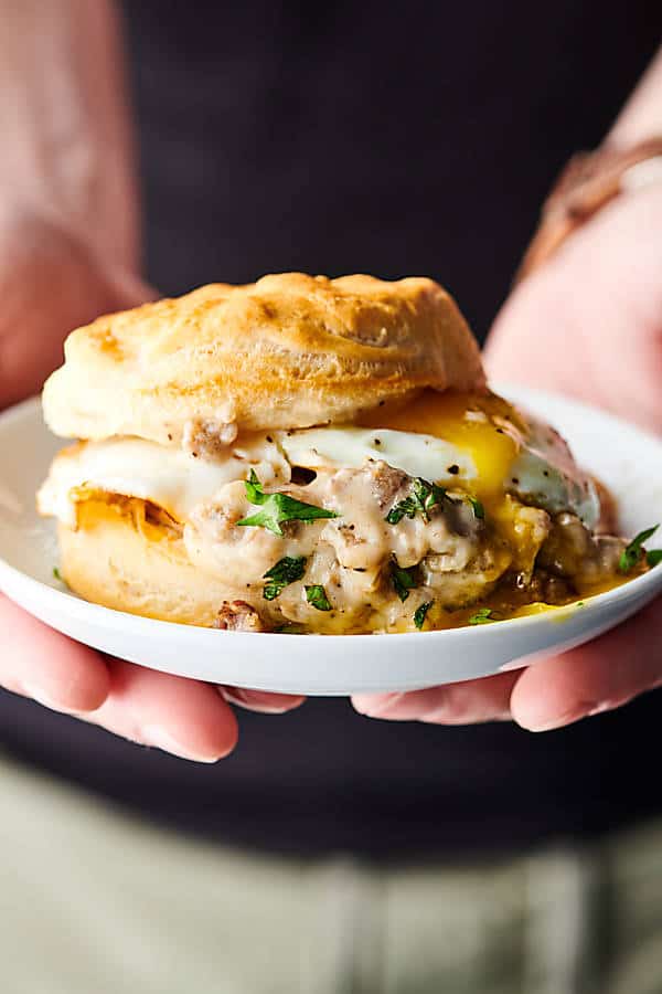 holding a plate of biscuits and gravy