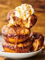 Stack of 3 apple pie bombs with ice cream and caramel drizzle.