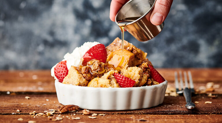 Maple syrup being drizzled over french toast casserole