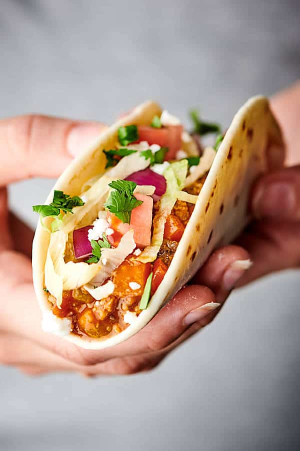 Open side view of taco held in two hands 
