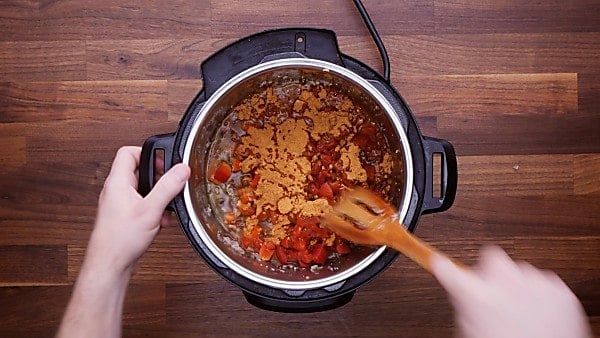 Instant pot turkey taco ingredients being stirred in instant pot