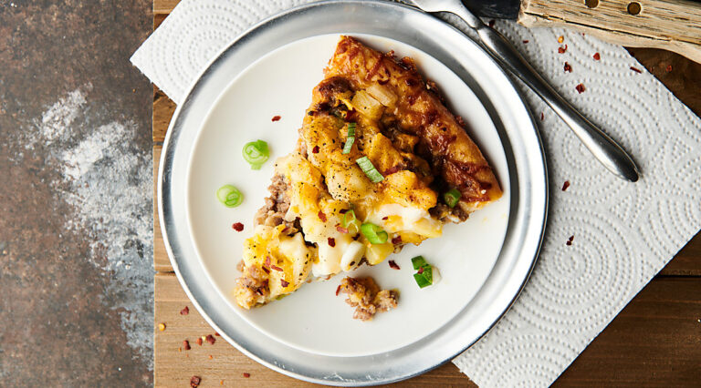 Overhead of slice of maple sausage breakfast pizza