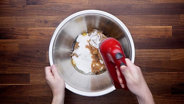 Monster cookie wet ingredients in bowl hand mixer