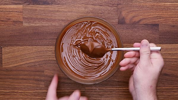 Melted chocolate sauce in bowl stirred
