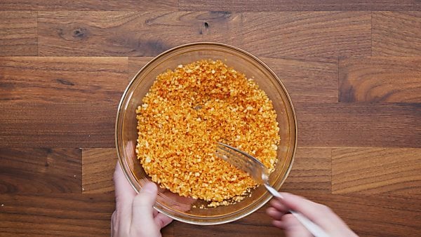 Mac and cheese topping being mixed in bowl