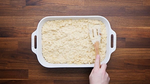 Macaroni and cheese sauce spread into baking dish