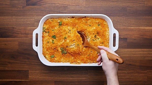 Baked mac and cheese with ladle being scooped out