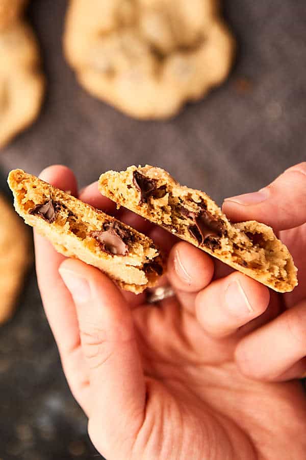 Chocolate chip cookie broken in half held above