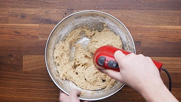 Cookie dough being mixed with hand beater