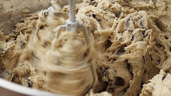 Chocolate chips being mixed into cookie dough