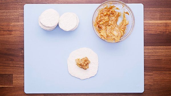 Biscuit dough on cutting board with filling