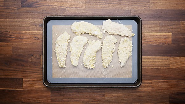 Unbaked chicken tenders on baking sheet