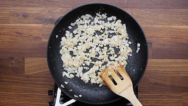 Onions and garlic being sauteed in skillet 