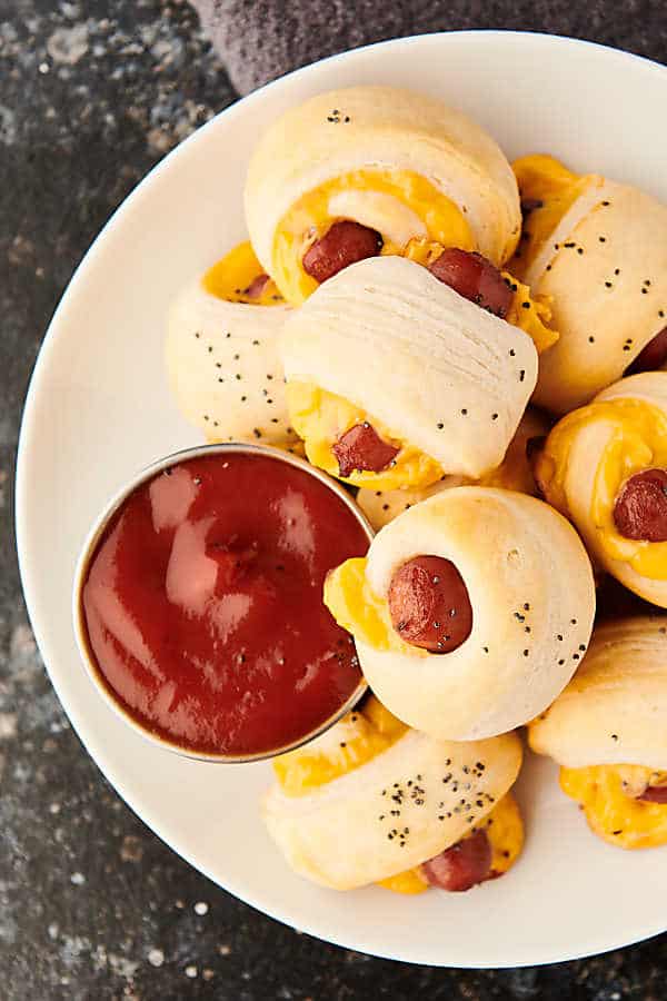 Plate of pigs in a blanket with ketchup above
