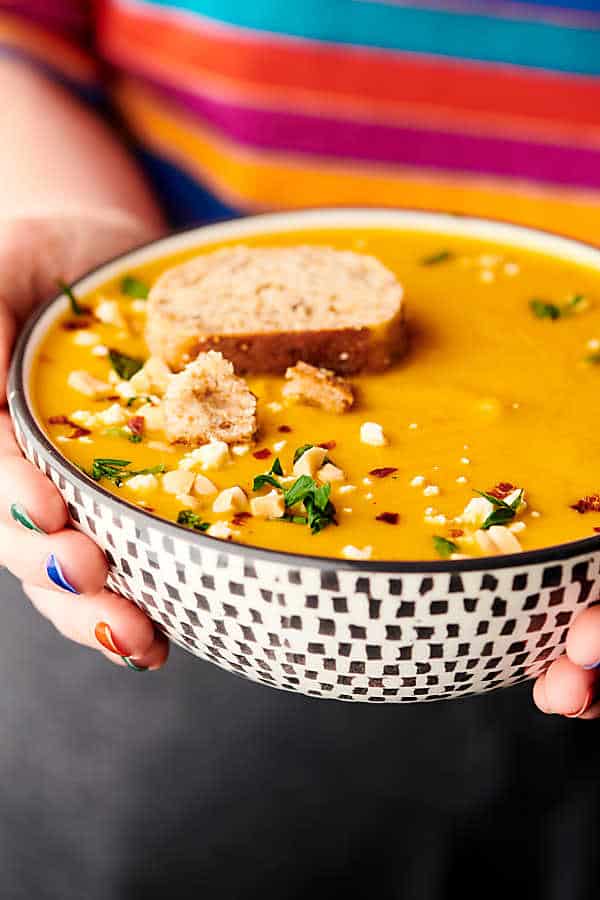 bowl of butternut squash soup held two hands