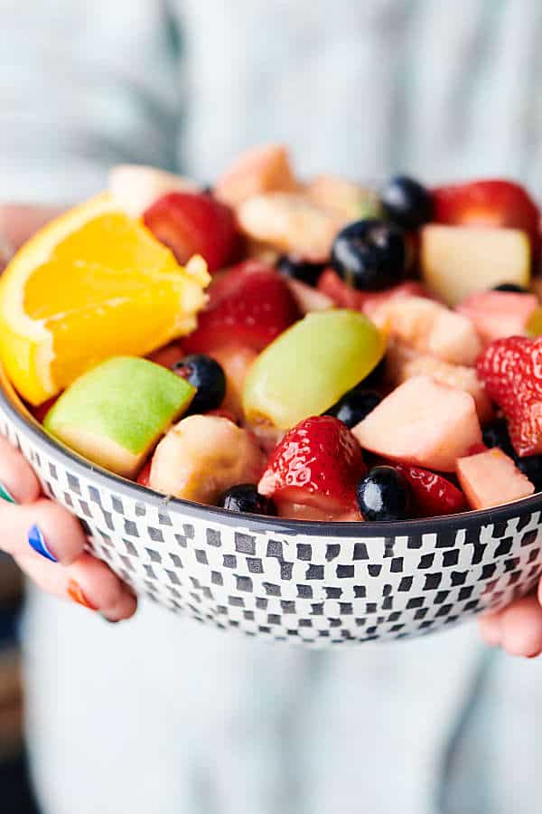 Bowl of fruit salad held