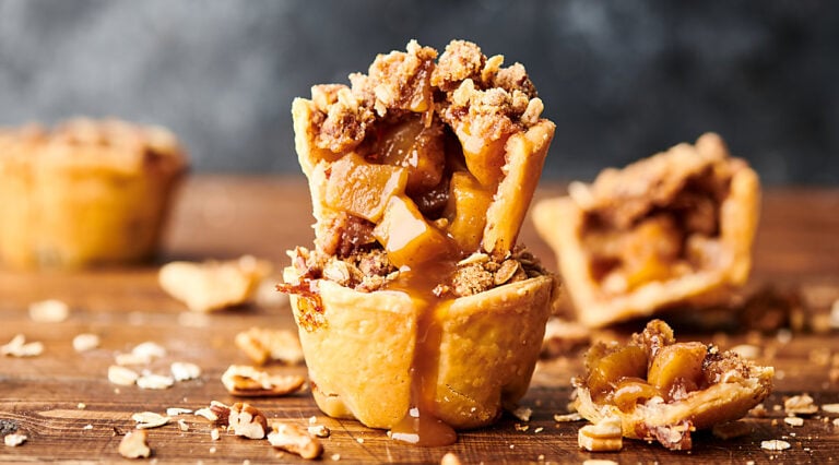 two mini apple pies stacked, others in background