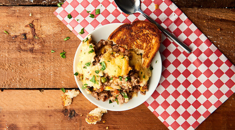 shepherd's pie on plate with garlic bread above