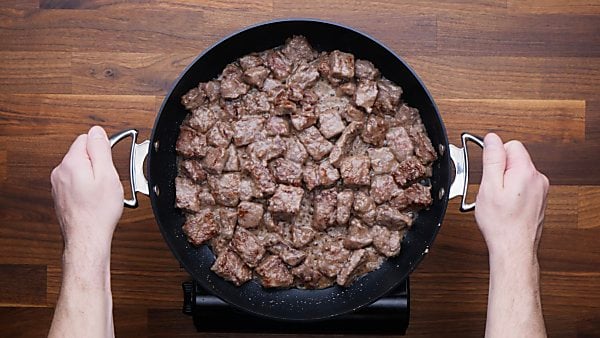 beef being cooked in pan